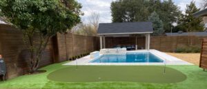 backyard with artificial turf and putting green