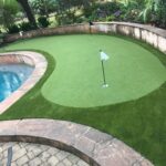 Residential backyard putting green next to pool