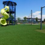 Commercial artificial grass playground with yellow slide