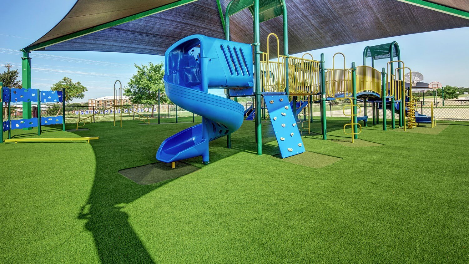 Blue slide installed on artificial playground grass