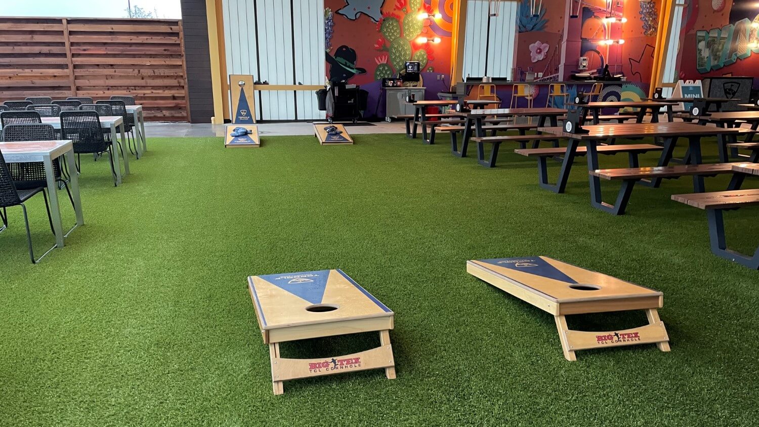 cornhole installed on artificial grass restaurant patio